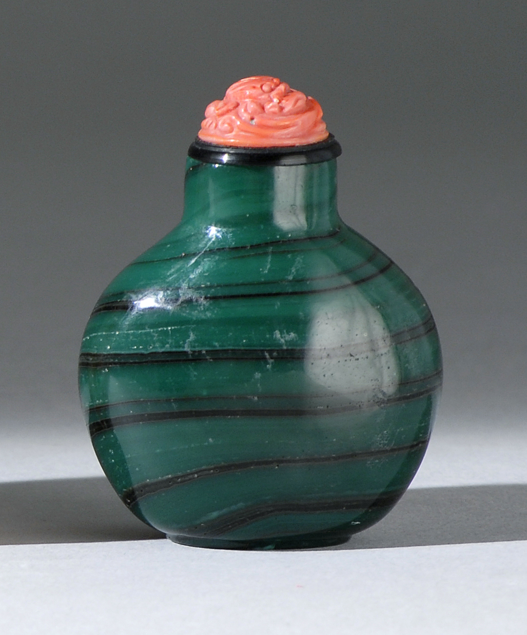 Appraisal: GREEN SWIRL GLASS SNUFF BOTTLE Mid- th CenturyIn ovoid form