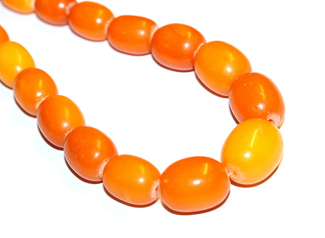 Appraisal: A GRADUATED AMBER BEAD NECKLACE oval shaped beads measuring mm