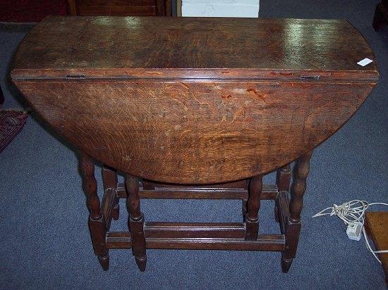 Appraisal: An oak gateleg table the half round flaps over turned