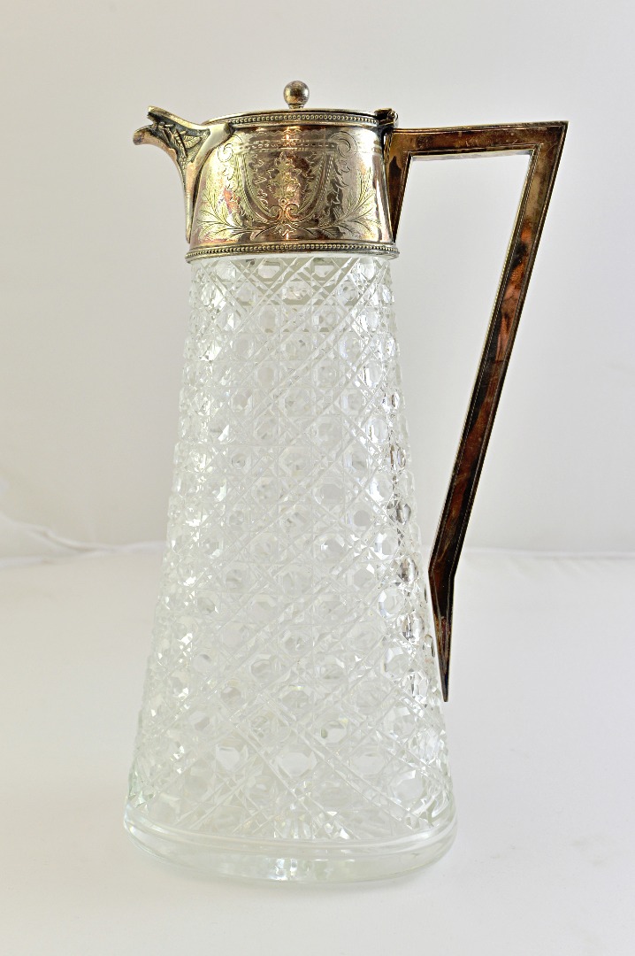 Appraisal: A silver plated metal mounted faceted glass claret jug of