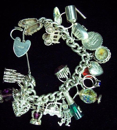 Appraisal: A silver charm bracelet with heart shaped padlock clasp hung