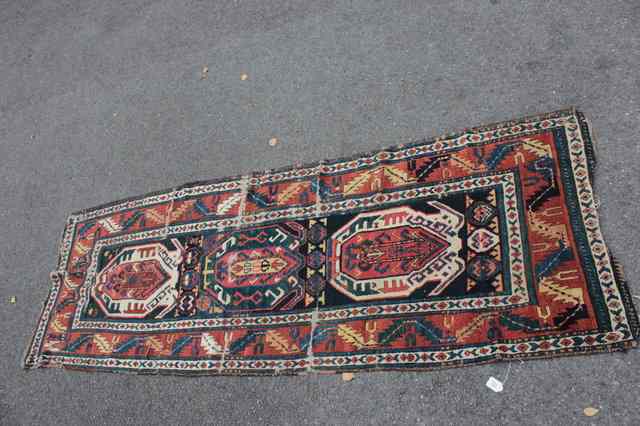 Appraisal: AN AZERBAIJAN RUST GROUND RUNNER with three interlocking central medallions