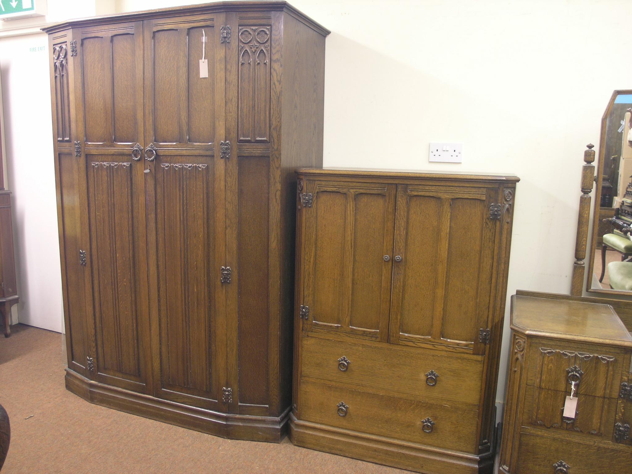 Appraisal: A dark oak bedroom suite panelled wardrobe enclosed by pair