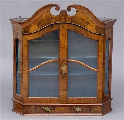 Appraisal: DUTCH ROCOCO WALNUT HANGING CABINET The swan's neck pediment above