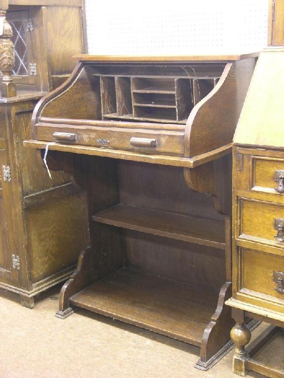 Appraisal: An early th century solid dark oak roll top desk