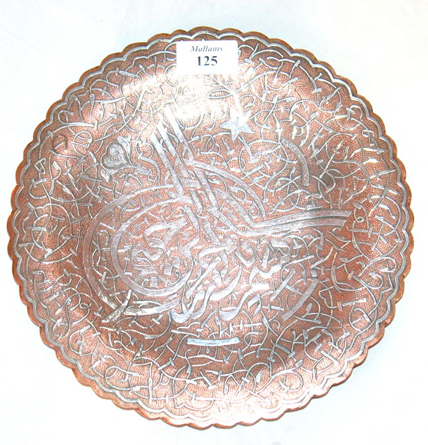 Appraisal: A PERSIAN COPPER DISH with silver scrolling decoration cm diameter