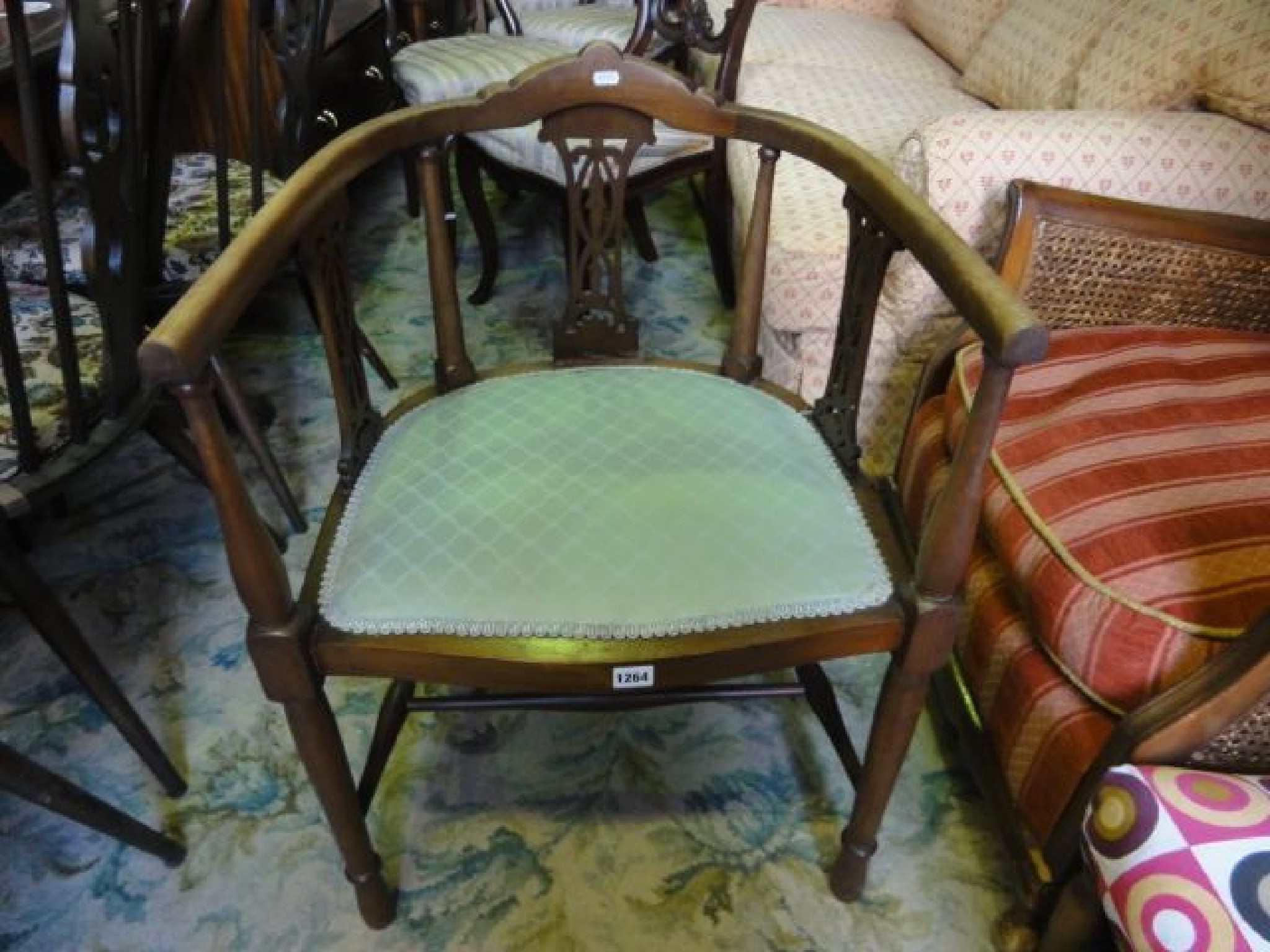 Appraisal: An Edwardian lightweight tub chair with arched moulded rail supported