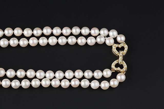 Appraisal: A CULTURED PEARL NECKLACE WITH DIAMOND SET CLASP comprising two