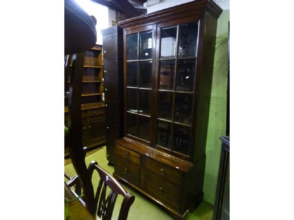 Appraisal: An oak bookcase with stepped and moulded cornice over a