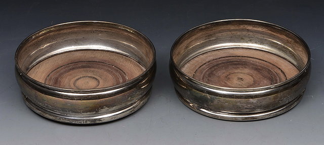 Appraisal: A PAIR OF SILVER WINE COASTERS with cedar bases and