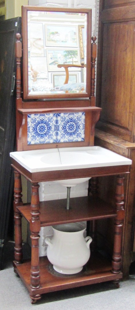 Appraisal: A late th century mahogany framed washstand with swing framed