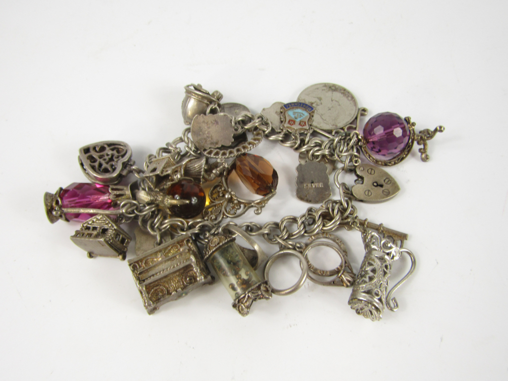 Appraisal: A silver charm bracelet on a heart shaped padlock clasp