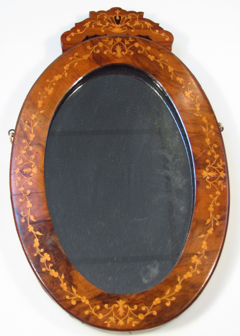 Appraisal: A thC walnut and marquetry inlaid mirror the oval glass