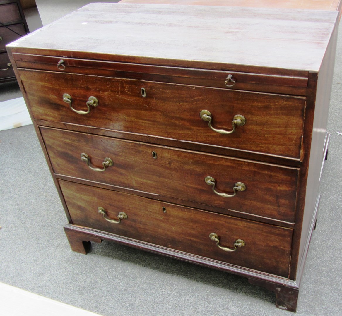 Appraisal: A George III mahogany chest the brushing slide over three