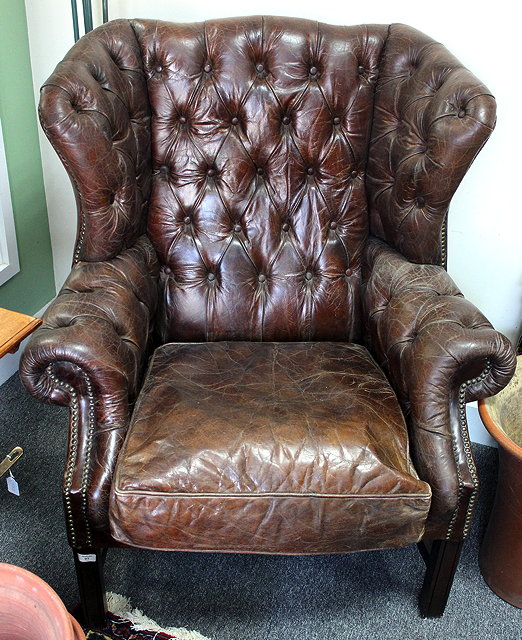 Appraisal: A GEORGIAN STYLE BROWN LEATHER BUTTONBACK UPHOLSTERED WINGBACK ARM CHAIR