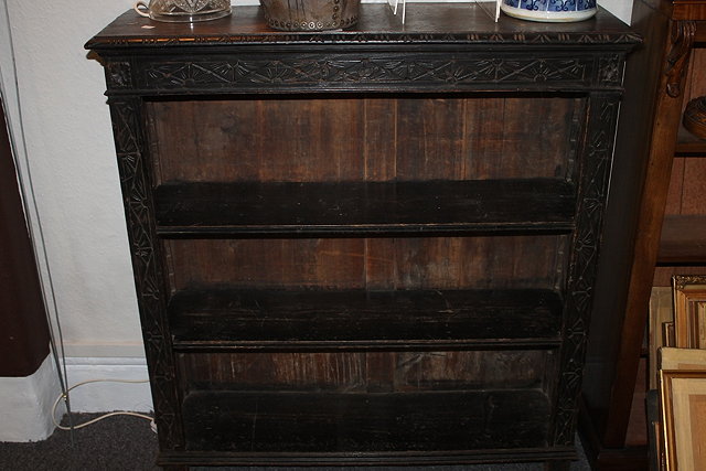 Appraisal: A VICTORIAN CARVED OAK OPEN BOOKCASE fitted two adjustable shelves