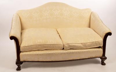 Appraisal: An arch back two-seat sofa the show wood frame on