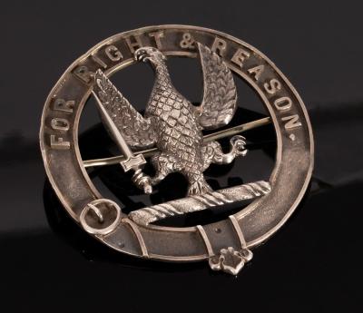 Appraisal: A Scottish white metal clan badge bearing crest and motto