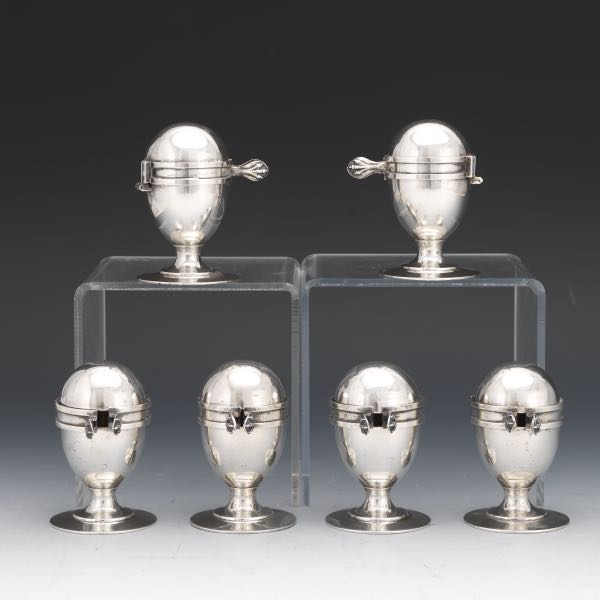 Appraisal: SIX EDWARDIAN STERLING SILVER WITH GOLD WASH EGG HOLDERS WITH