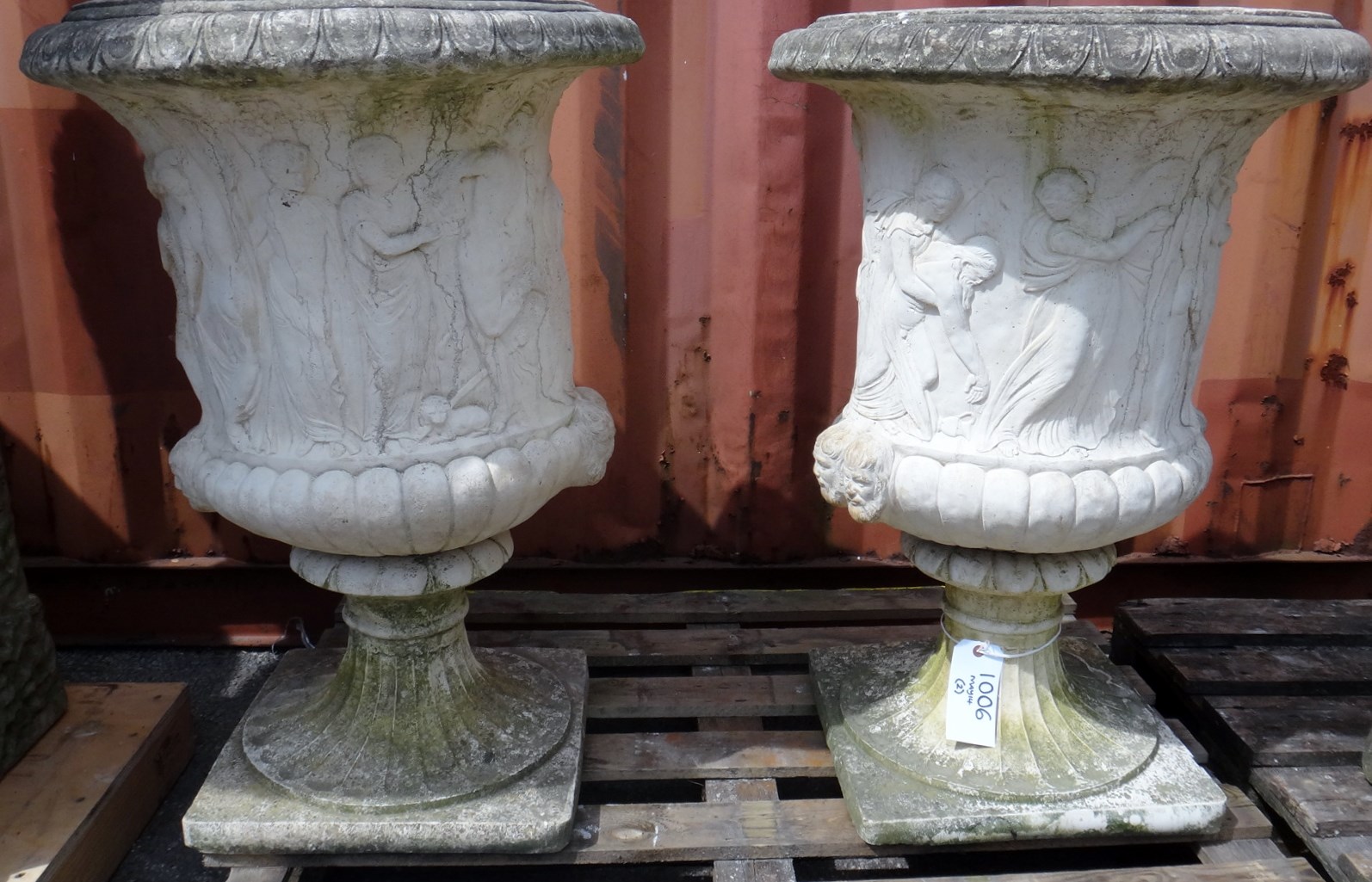 Appraisal: A pair of reconstituted stone baluster garden urns relief moulded