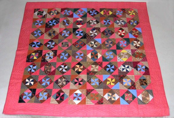 Appraisal: Pinwheel quilt Multicolor pinwheels in squares Reddish-pink border Brown paisley