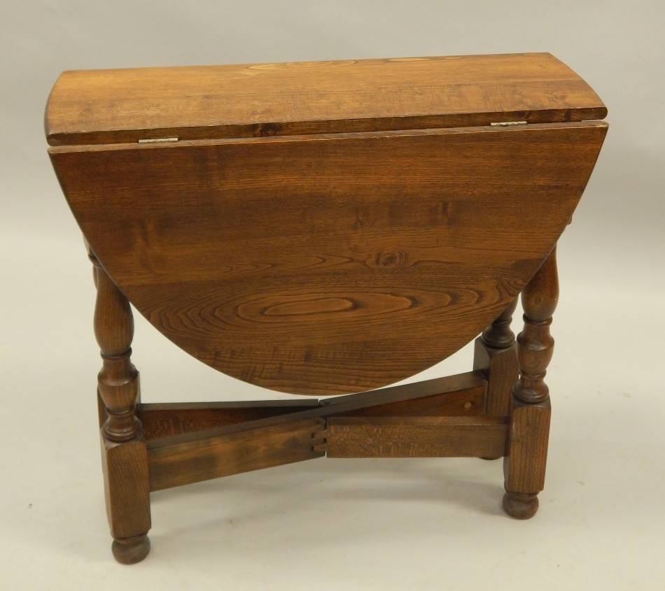 Appraisal: A reproduction oak drop leaf table on turned supports oval