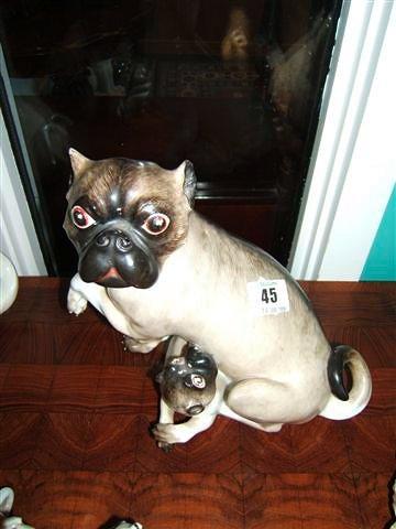 Appraisal: A Continental porcelain pug suckling her puppy high