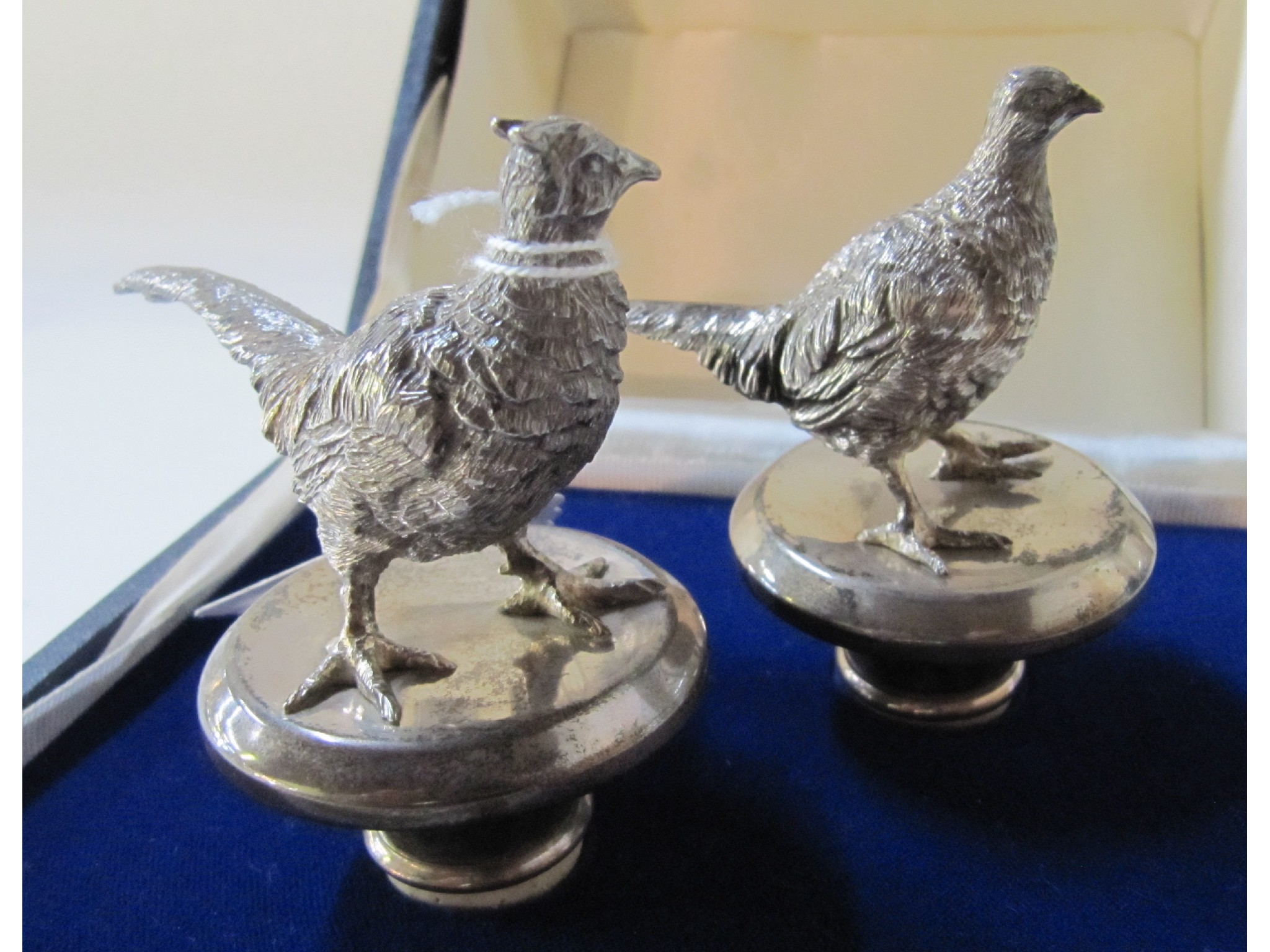 Appraisal: A pair of sterling silver bottle stoppers modelled as cock