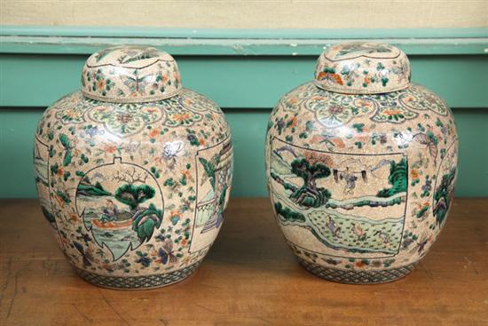 Appraisal: PAIR OF COVERED JARS Porcelain jars with polychrome village floral