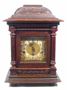 Appraisal: An oak cased mantel clock with parcel gilded Gothic style