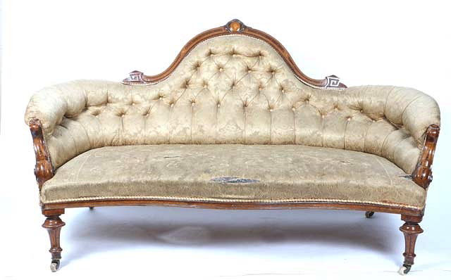 Appraisal: A VICTORIAN WALNUT FRAMED SOFA with shaped button upholstered back