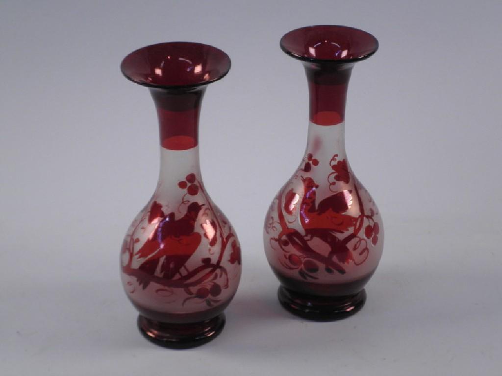 Appraisal: A pair of Bohemian type ruby tinted vases each decorated