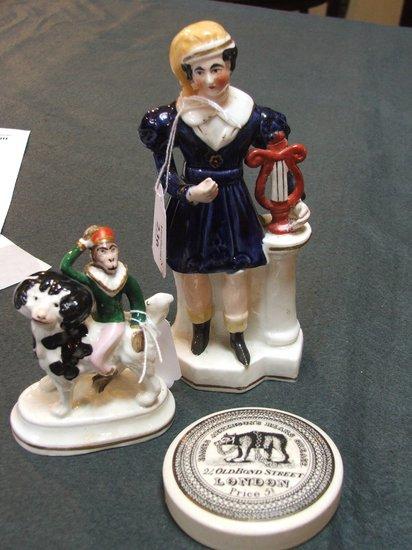 Appraisal: A STAFFORDSHIRE FIGURE of a young boy standing and holding