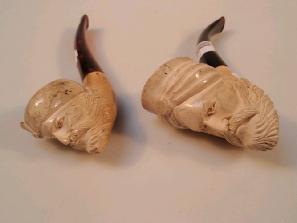 Appraisal: Two carved pipes of turbaned male masks with amber stems