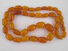 Appraisal: A graduated amber bead necklace the largest bead approx x