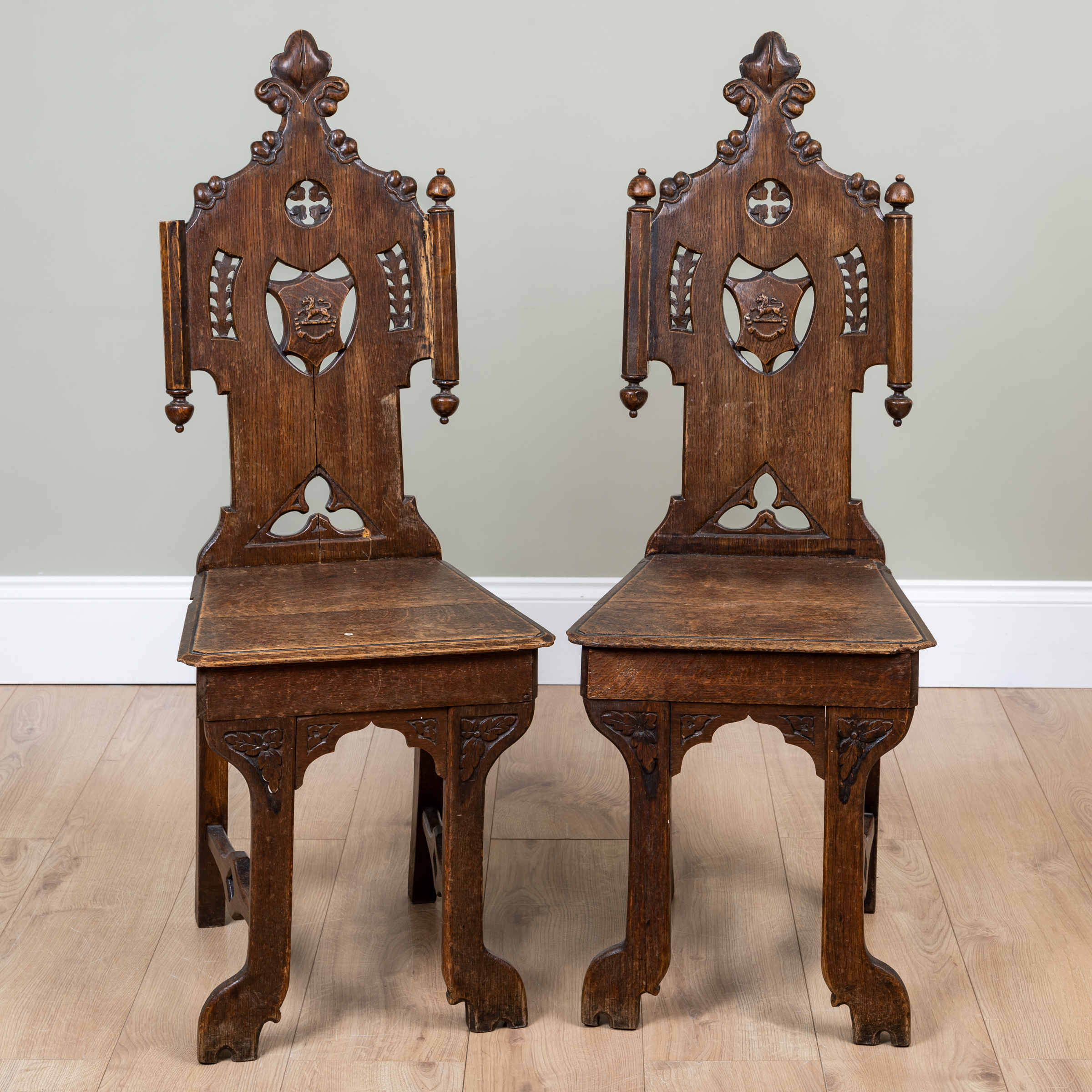 Appraisal: A pair of Victorian oak hall chairs with pierced shaped