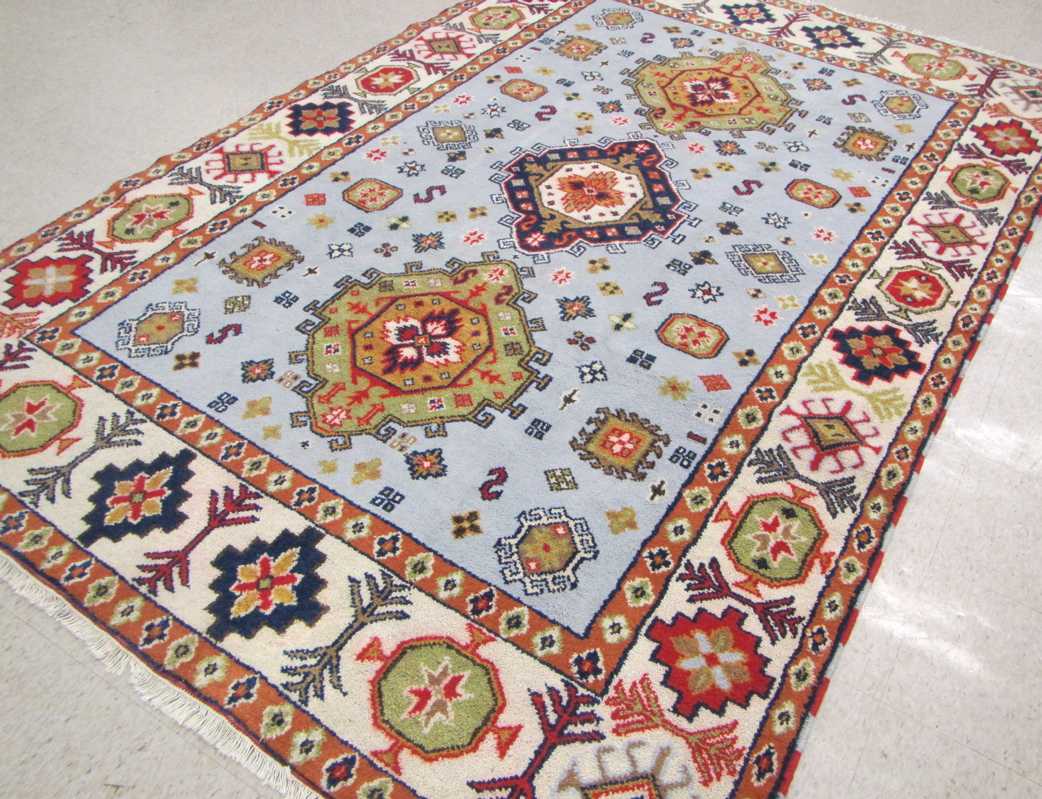 Appraisal: HAND KNOTTED ORIENTAL CARPET Indo-Caucasian three geometric medallions and other