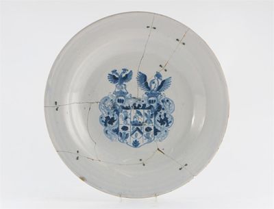 Appraisal: A Delft armorial dish painted in blue with a coat