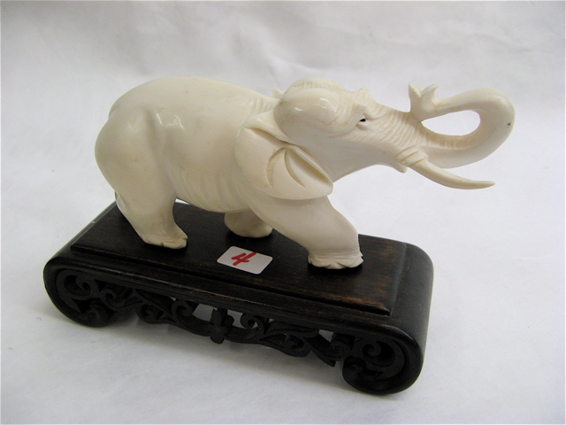 Appraisal: CARVED IVORY ASIAN ELEPHANT with upraised trunk attached to shaped