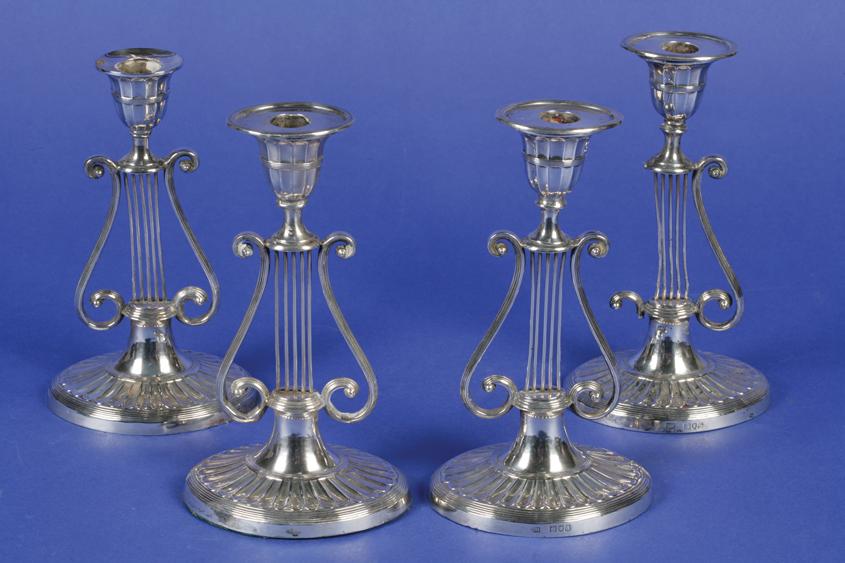 Appraisal: A SET OF FOUR LATE VICTORIAN CANDLESTICKS with lyre-shaped stems