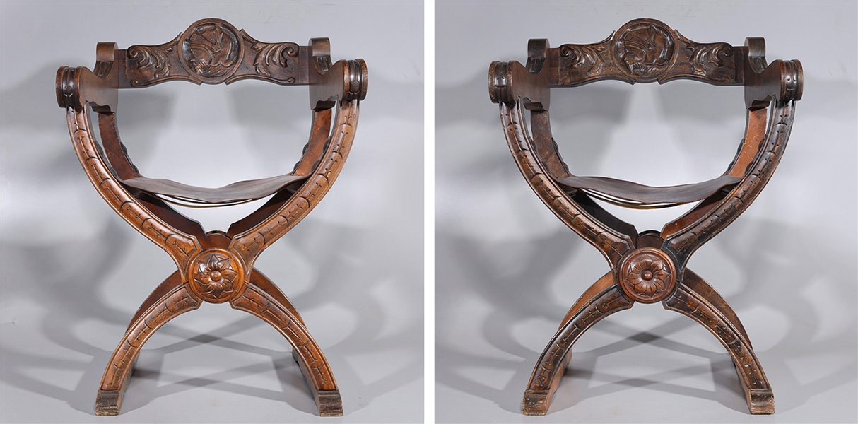 Appraisal: Pair of carved wooden folding chairs with leather seats late