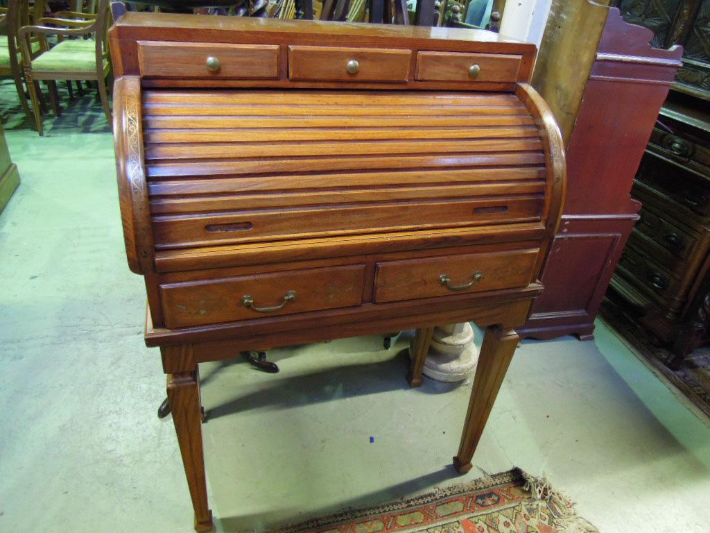 Appraisal: A hardwood cylinder roll top desk with brass inlaid detail