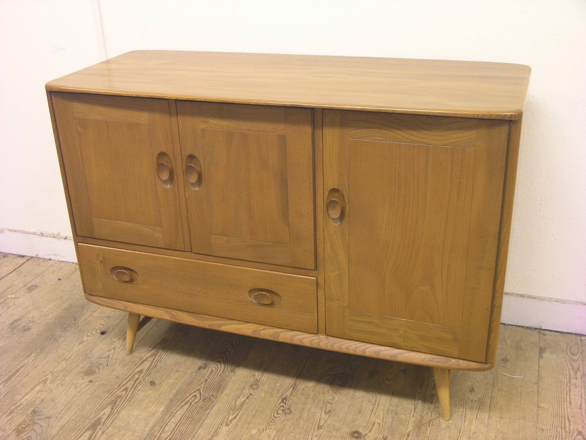 Appraisal: An Ercol medium elm sideboard enclosed by three cupboards and