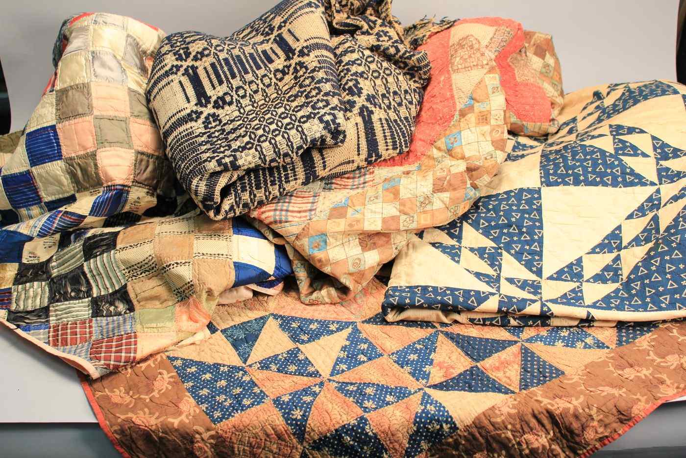 Appraisal: FOUR ANTIQUE AMERICAN QUILTSTogether with a blue and white jacquard