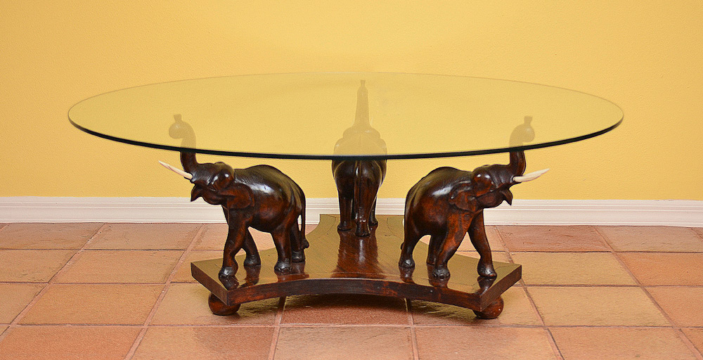 Appraisal: CARVED ELEPHANT BASE GLASS TOP COFFEE TABLE figural carved elephants