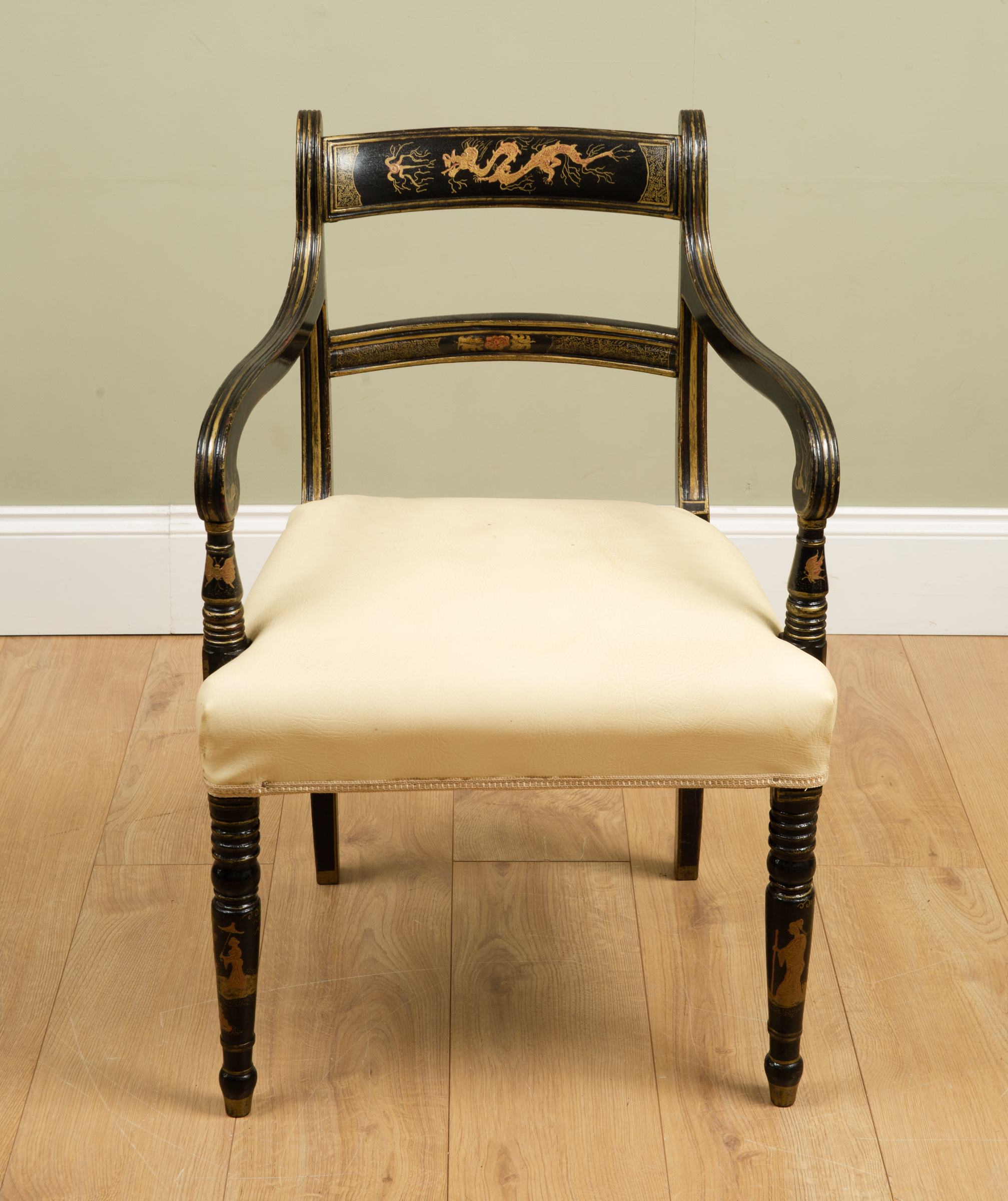 Appraisal: A black lacquered elbow chair with bar back leatherette upholstered