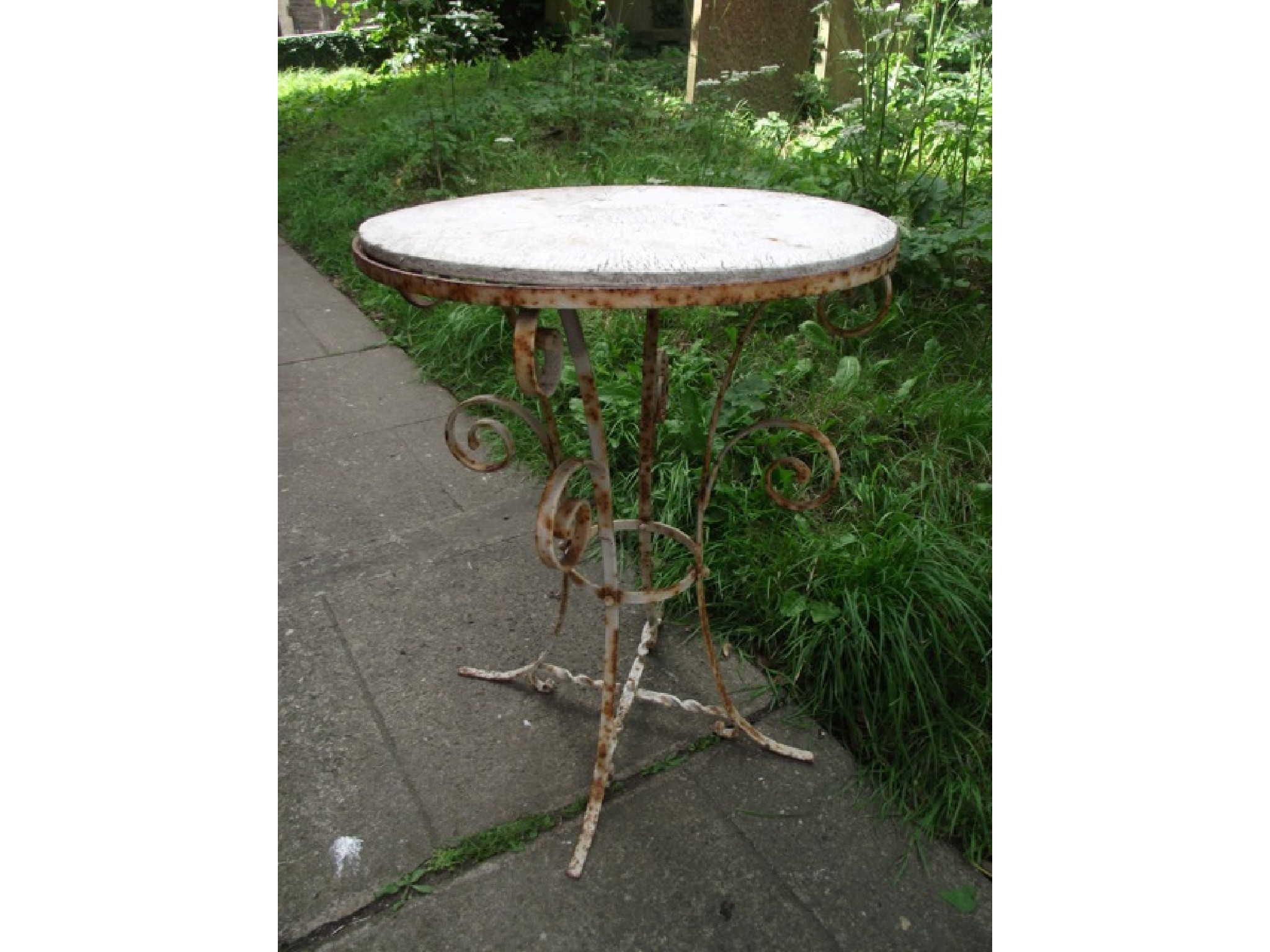 Appraisal: A small ironwork garden table of circular form raised on