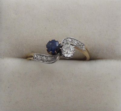 Appraisal: A sapphire and diamond cross over ring Set with smaller