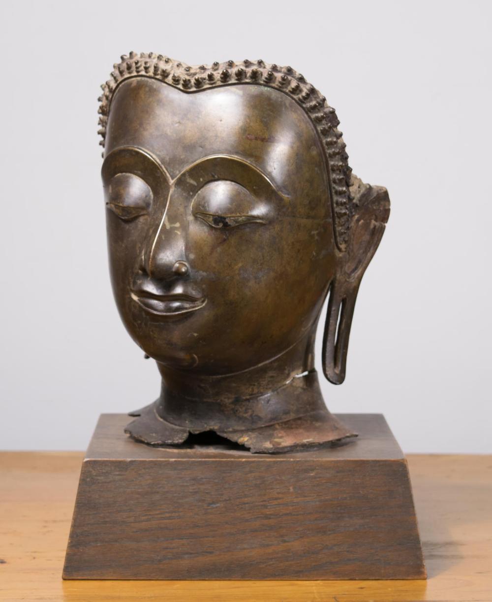 Appraisal: BRONZE BUDDHA MASK SCULPTURE raised on a rectangular wooden base