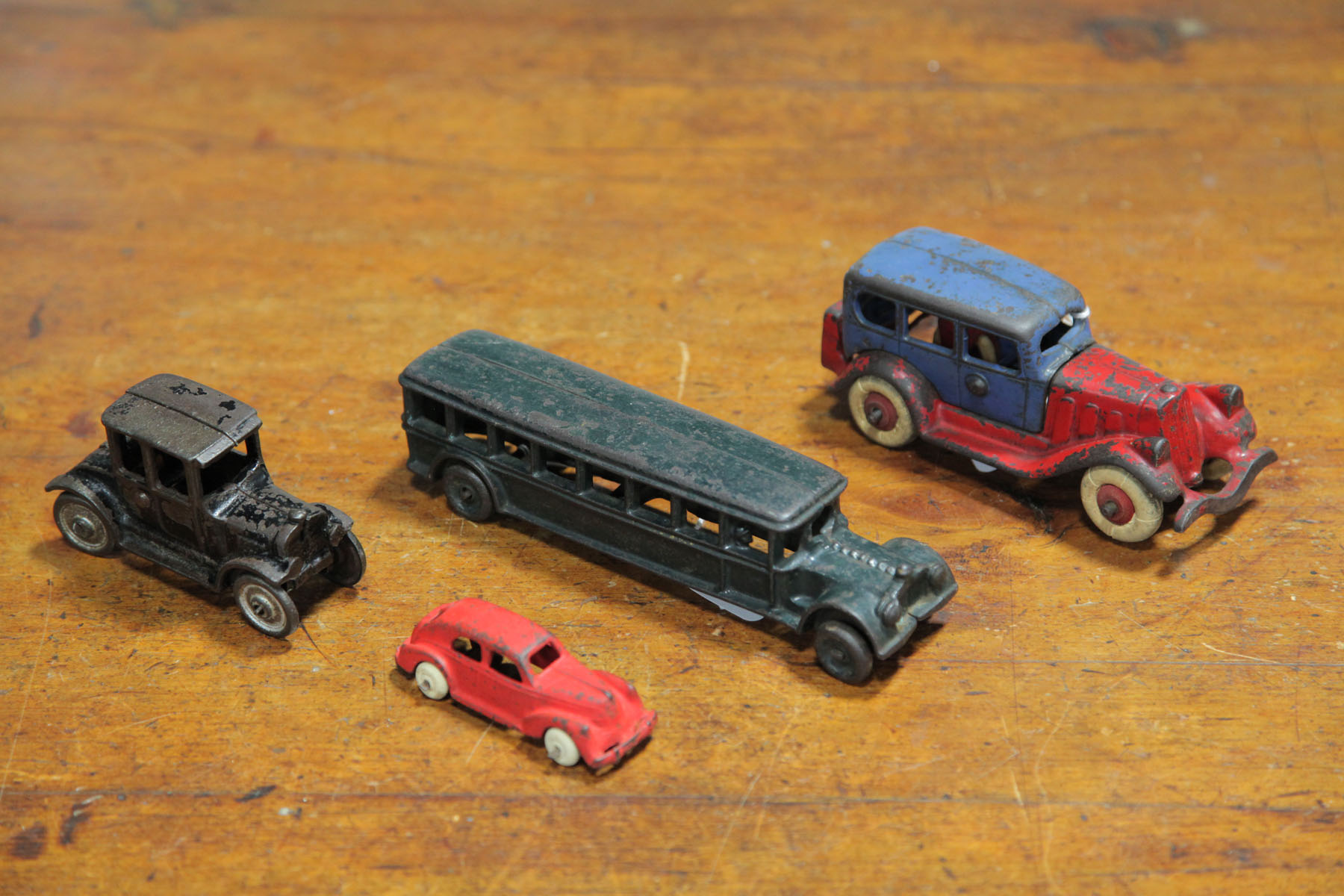 Appraisal: FOUR CAST IRON AUTOMOBILES American early th century A red